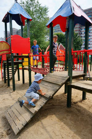 POZNAN, POLAND - Jul 20, 2017: Three years old child on a climb equipment at a playground in the Orla Bialego districtのeditorial素材