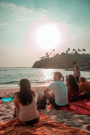 GALLE, SRI LANKA - Feb 15, 2019: Group of friends at the beach watching sunsetのeditorial素材