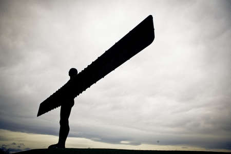 A silhouette of Angel of the North statue in Gateshead, Tyne and Wear, England under the dark cloudy skyのeditorial素材