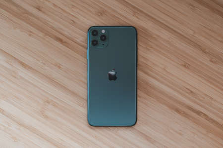 PORTLAND, UNITED STATES - Oct 11, 2019: A high angle shot of a phone in a black case on a wooden...