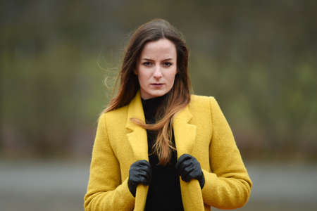 FRANKFURT, GERMANY - Jan 01, 2014: Young lady with yellow jacket, fashion portrait shots on the streetのeditorial素材