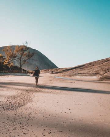 RIO DE JANEIRO, BRAZIL - Jan 11, 2020: A girl walking on a beach in Rio de Janeiro, early morning...