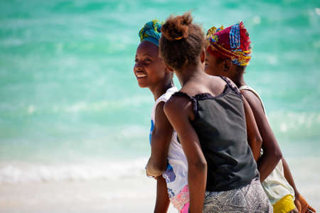 AMBATOMILO, MADAGASCAR - Aug 15, 2019: Three friends walking on the beachのeditorial素材