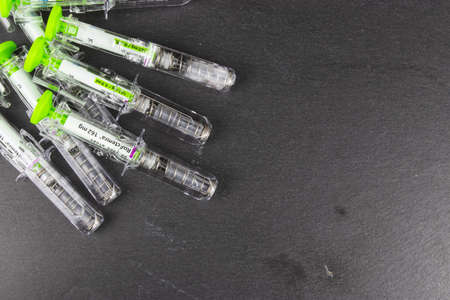 LEEDS, UNITED KINGDOM - Jan 27, 2019: A pile of used Tocilizumab  injections on a slate background.のeditorial素材