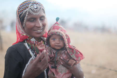 PUSHKAR, INDIA - Nov 05, 2011: A women holds her child in India.のeditorial素材