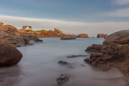 A beautiful shot of the seashore with rocks of different sizes under the skyのeditorial素材
