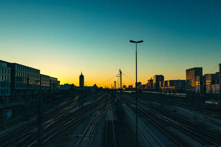 A picture of railways surrounded by modern buildings with the sunset on the backgroundの写真素材