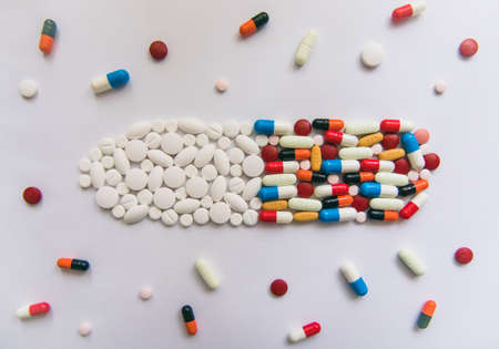 A high angle view of colorful pills under lights against a white backgroundの写真素材