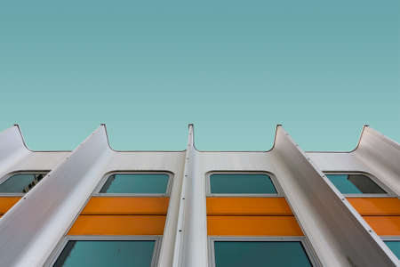 A low angle shot of a white and yellow modern building under the blue skyの写真素材