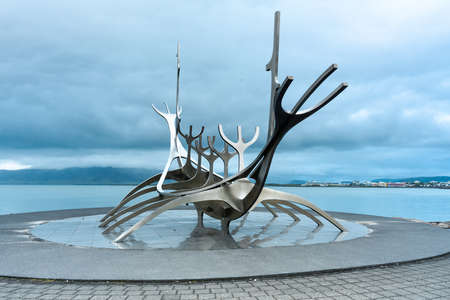 An interesting modern statue at the beach under the cloudy sky