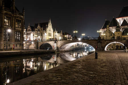 A beautiful shot of a concrete arch bridge with lights at night under the dark skyのeditorial素材