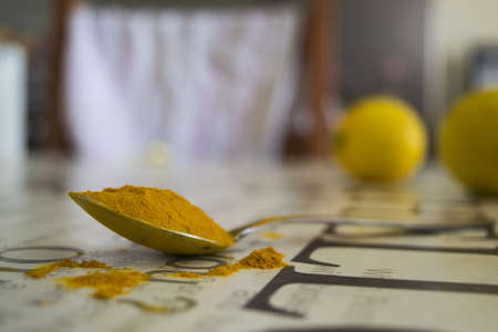 selective focus shot of turmeric powder on a metal spoon