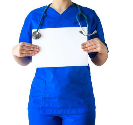 A young female doctor in a blue medical uniform holding a blank white paper with a copy space isolated on a white backgroundの写真素材