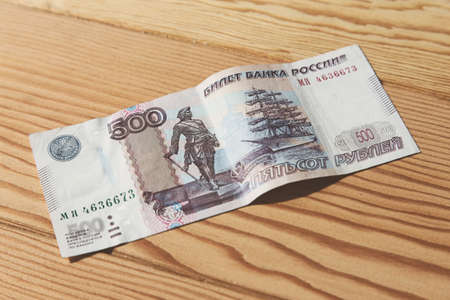 A high angle closeup shot of a banknote on a wooden surface