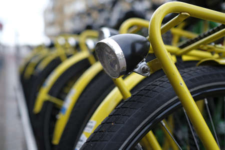 A selective focus shot of a front light on a yellow bicycle