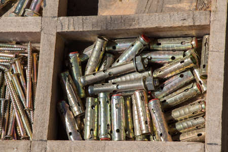 A high angle closeup shot of metal fragments for equipment in a wooden box