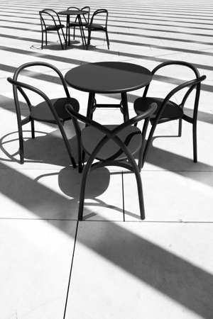 A beautiful black and white shot of chairs and tablesの写真素材