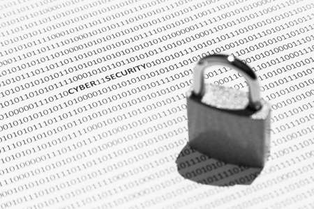 A selective focus shot of a lock on a white surface with cyber security written on it