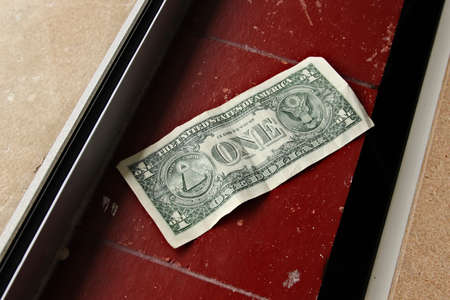 A high angle shot of an American dollar bill on a tiled surface