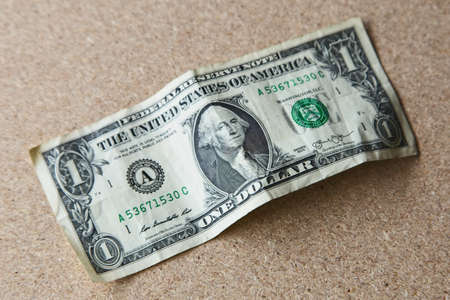 A high angle shot of a one American dollar on a wooden surface