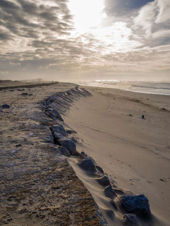 A vertical high angle shot of the sandy ground under the cloudy sky