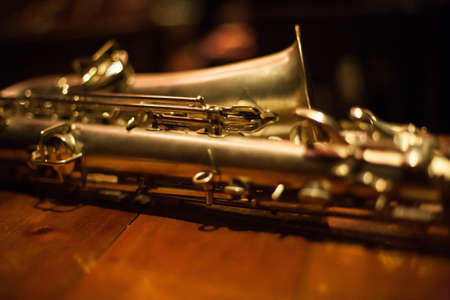 A closeup shot of a baritone saxophone on a wooden tableの写真素材