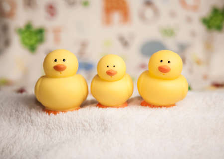 Three cute yellow duck toys in a child's room
