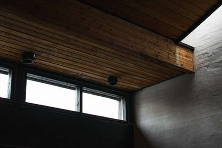 An inside shot of a building with a wooden ceiling and windows during daytime
