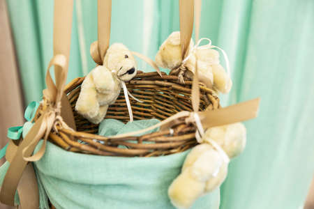 A basket with toy bears on it covered by a blue fabric under the sunlightの写真素材
