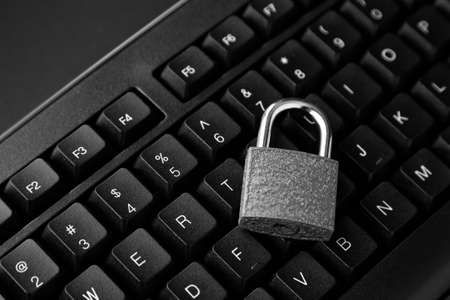 A high angle shot of a lock on a black computer keyboard