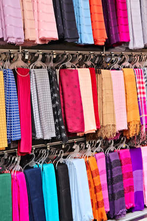 A vertical shot of a selection of colorful scarves in a storeの写真素材