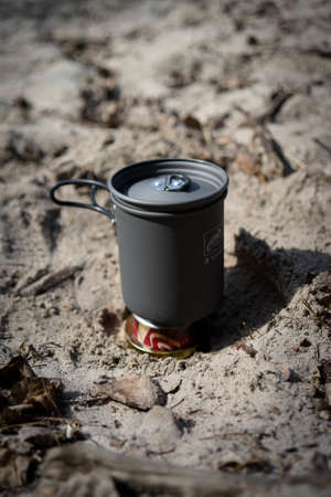 A close up shot of a camping pot set on a tin can