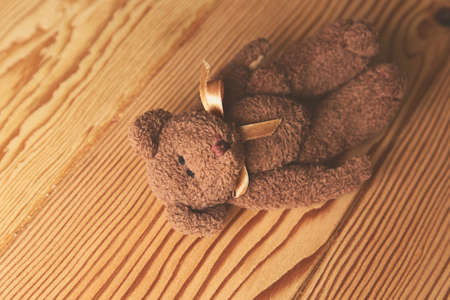 A high angle shot of a cute teddy bear on a wooden surfaceの写真素材