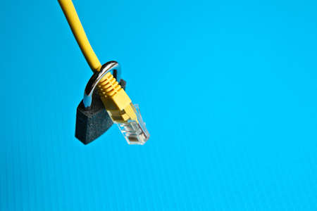 A high angle shot of a yellow cable and lock over a blue surfaceの写真素材