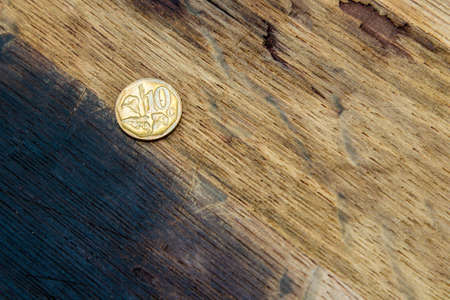 A high angle shot of a coin on a wooden surfaceの写真素材
