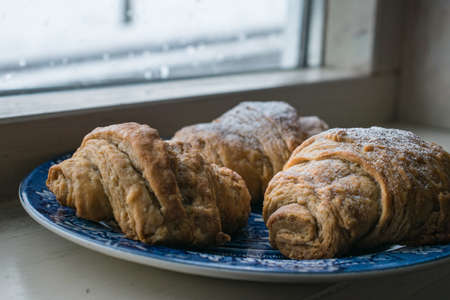 A closeup shot of freshly baked pastry in a blue plate with a blurred background