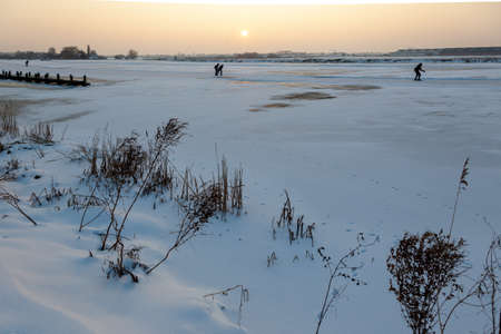 A snowy field with people snowboarding in the distance