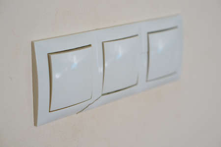 A closeup shot of a modern light switch on a beige wall