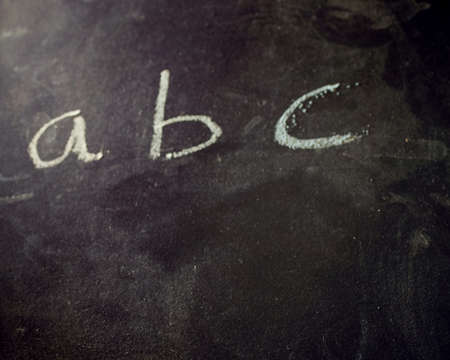 A closeup of first english alphabet letters written on a blackboard with a chalkの写真素材