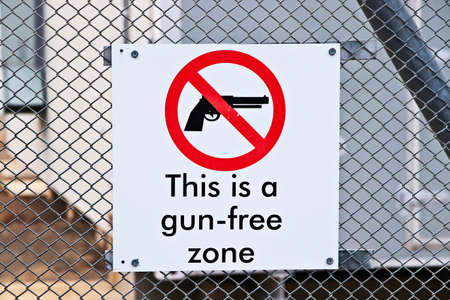 A closeup shot of a gun-free zone sign on a fence