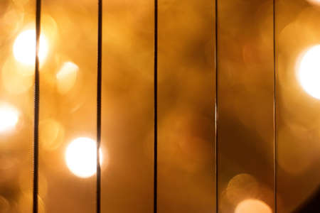 The bright golden background behind the vertical iron sticks