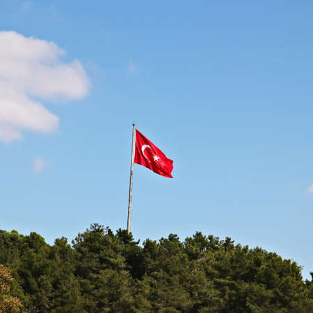 A low angle shot of the Turkish flag under the clear sky