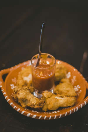 A vertical shot of fried food and a sauce in the middleの写真素材