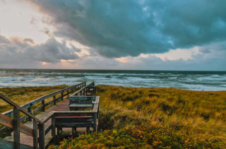 A wooden bridge on the beach surrounded by the sea at the Island Sylt in Germany