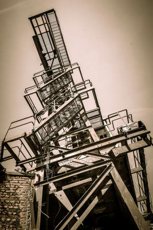 A low angle shot of stairs and railings made of metal heading to the top of a building at daytime