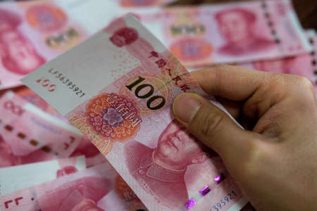 A closeup shot of a person holding Chinese Yuan