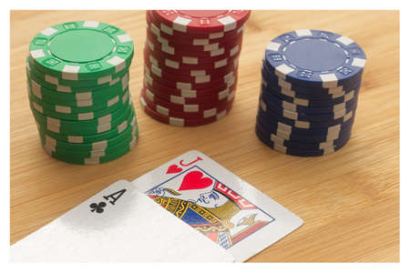 A high angle shot of playing cards and poker chips on a wooden surface