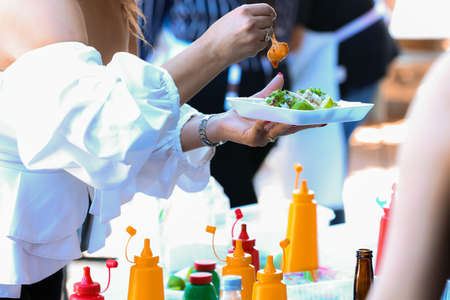 A female holding a plate of salad in her hands at a banquet