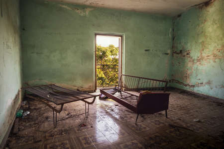 An interior shot of an old abandoned building with cracked up walls in Italyの写真素材