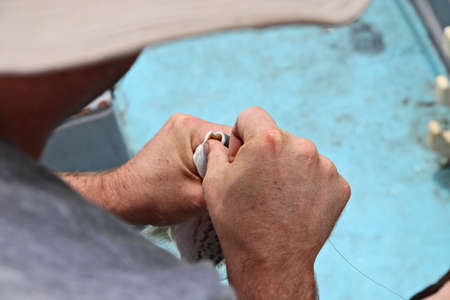 A closeup shot of a male killing a caught fish